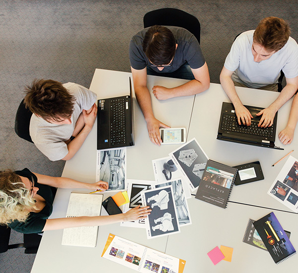 Schüler besprechen grafische Entwürfe ihres Projekts