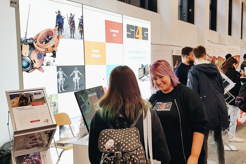 Schülerin berät Interessentin am S4G Messestand